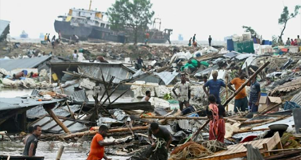 Des habitants recherchent des affaires dans les débris de leurs cabanes après le passage du cyclone Sitrang, le 25 octobre 2022 à Chittagong, au Bangladesh.