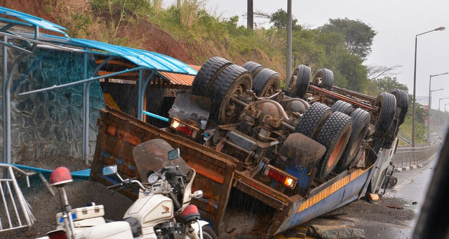 Un camion chargé de matériaux de construction finit sa course sens dessus dessous